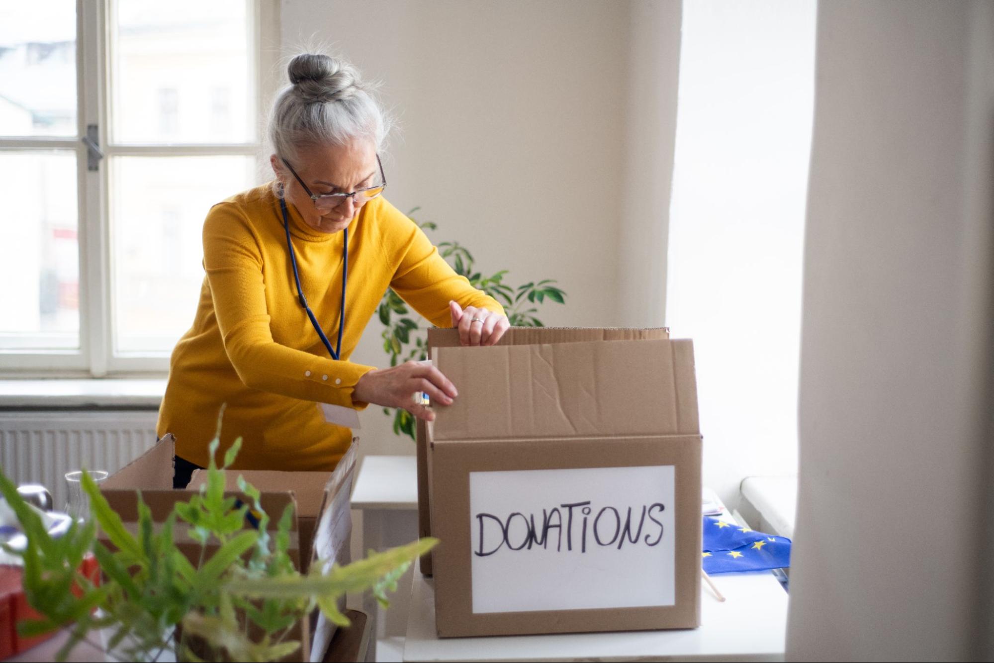 A person packing a box for donations.