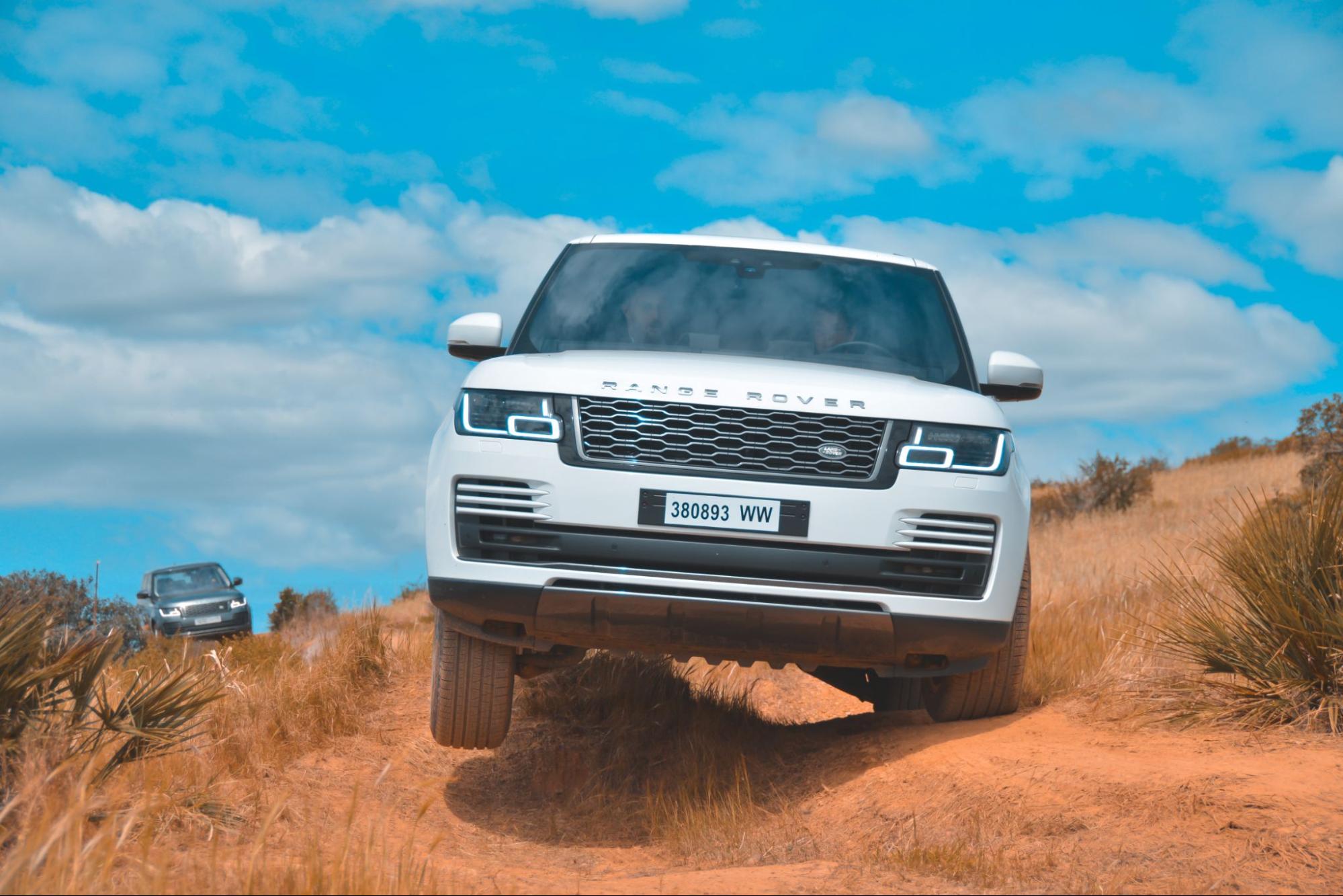 A white car on a dirt road.