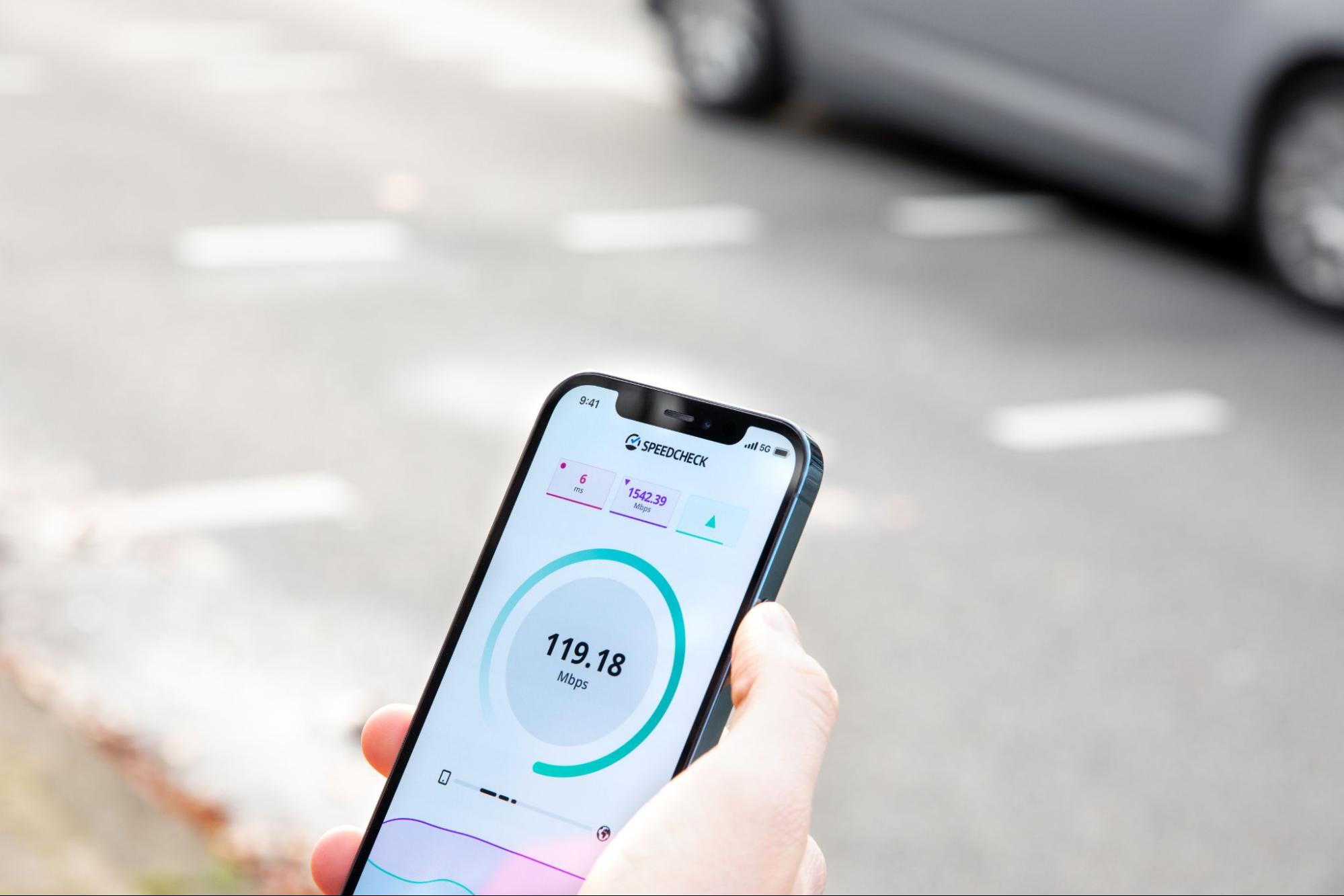 A hand holding a phone with network speed checker. 