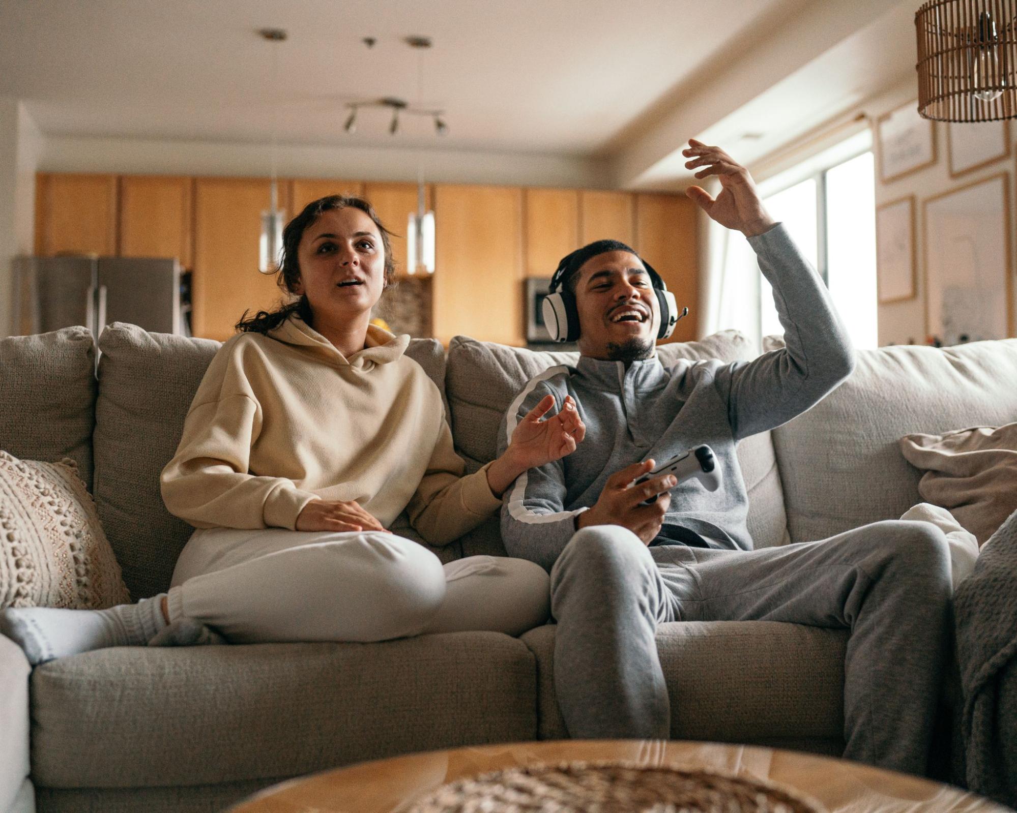 Two people on the sofa playing video games.