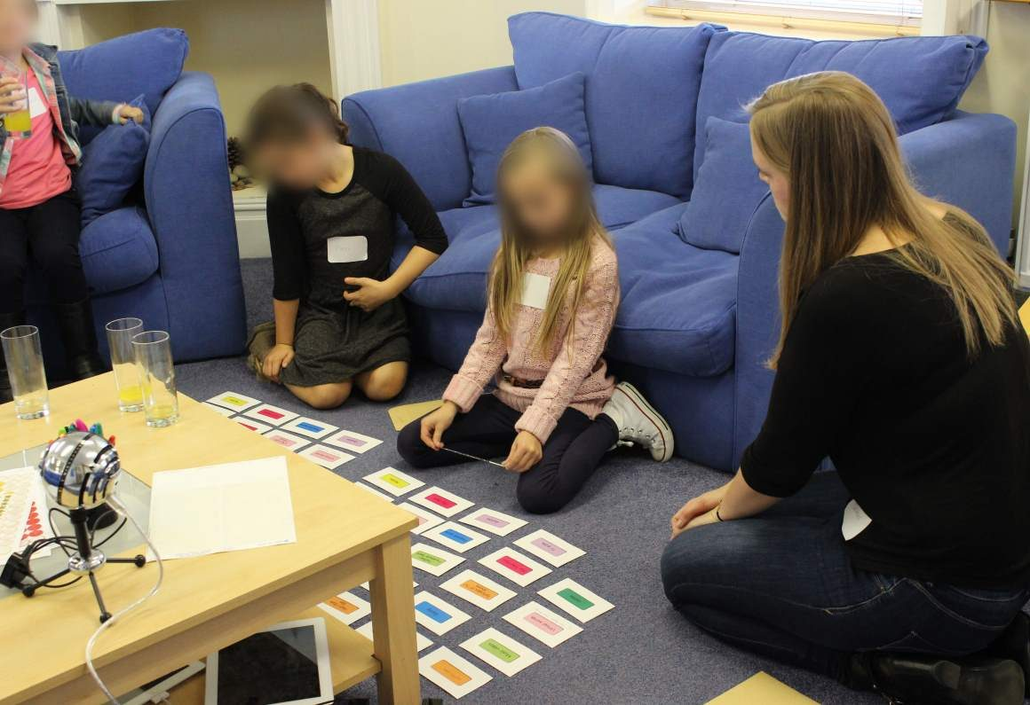 Children sitting on the floor with colourful cards for a focus group.